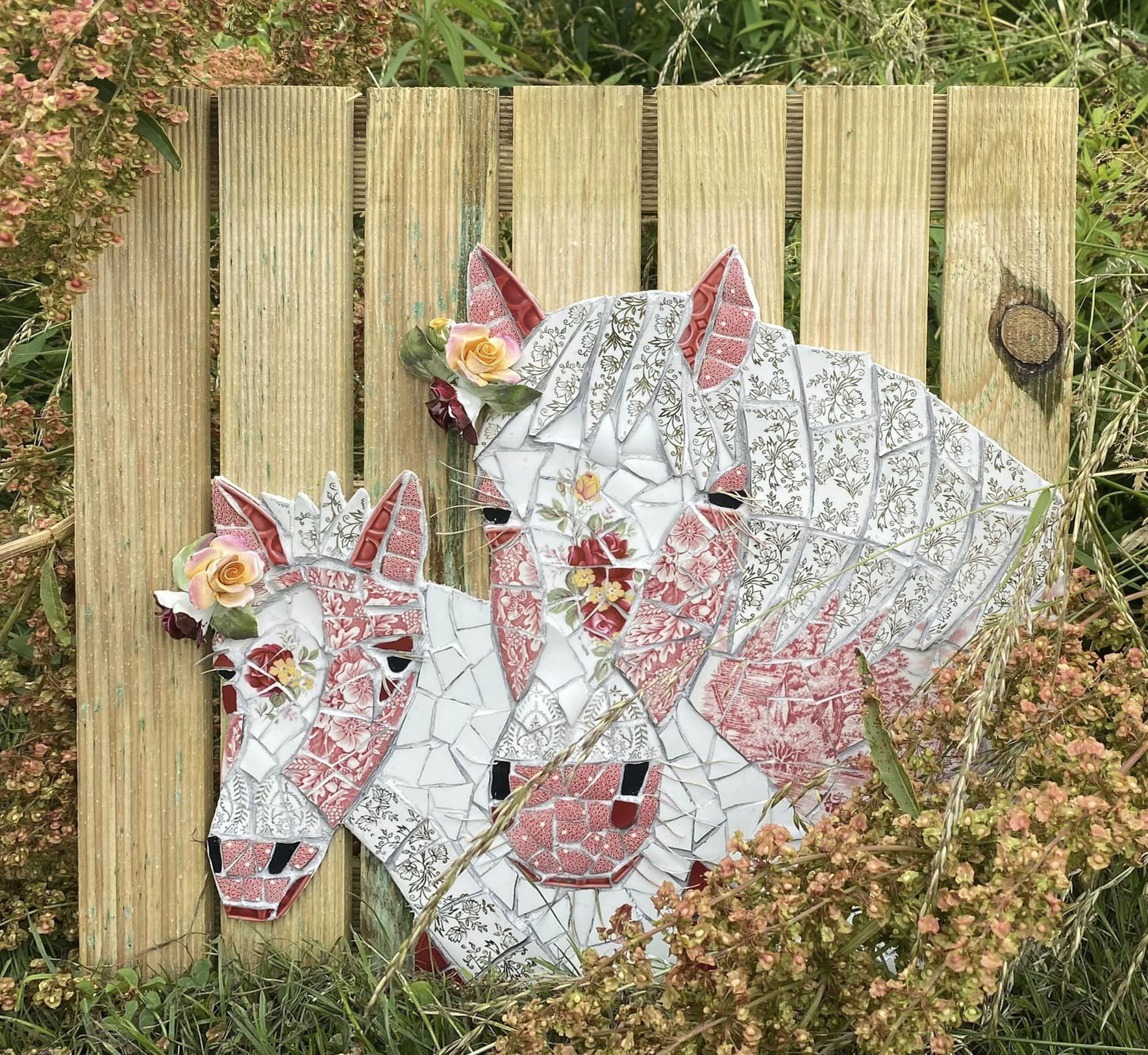 Vintage crockery mosaic horses on mosaic mesh on decking tile. Vintage roses from an ornament.