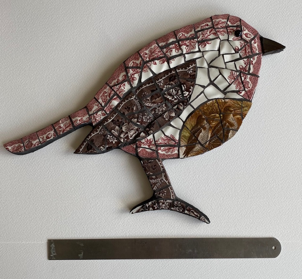 Mosaic bird is vintage crockery on cement board for indoors or outdoors. Black grouting.