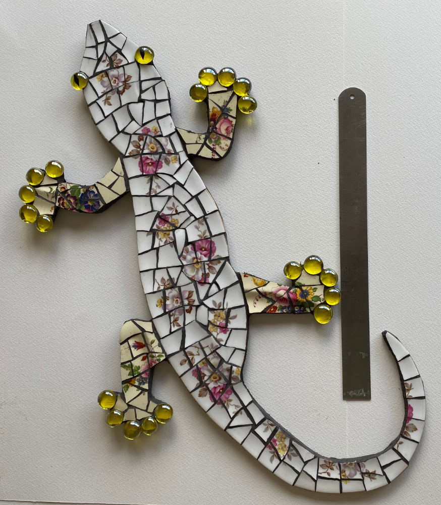 Mosaic gecko is vintage crockery on on cement board for indoors or outdoors. Black grouting.