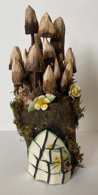 small log fairy house with hand carved toadstools and fungus with vintage roses.
