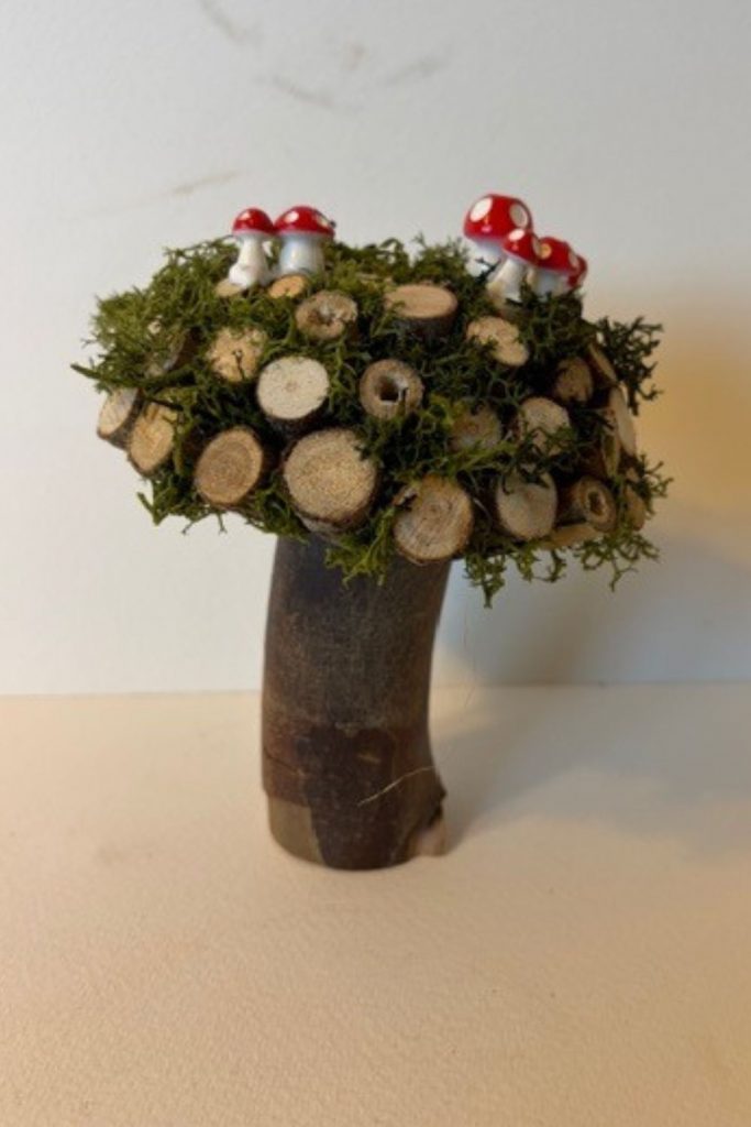This mushroom ornament is sculpted from an eco-conscious resin dome, The surface is carefully adorned with natural wooden log slices and preserved moss, creating rich texture and an authentic woodland feel. Set upon a solid log stem, the piece feels both grounded and sculptural—an elegant fusion of natural elements and contemporary craftsmanship. Each ornament is entirely unique, echoing the quiet beauty of the forest floor in a refined, decorative form.